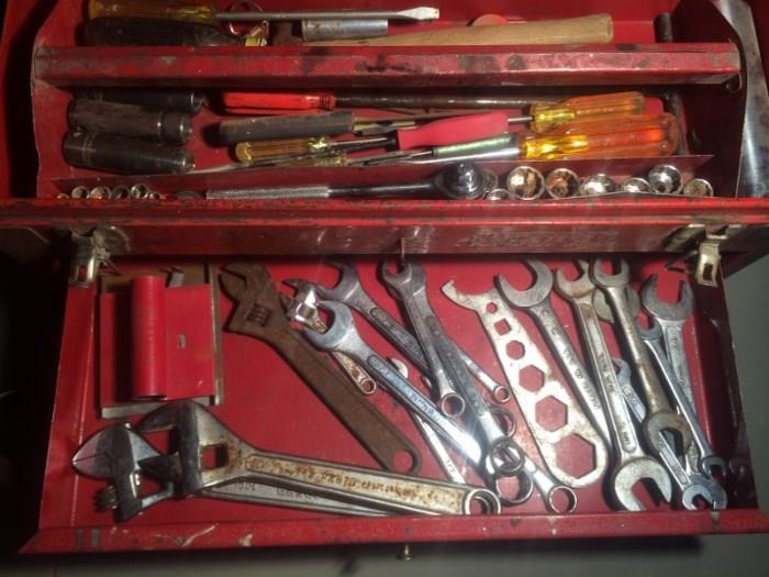 Red metal tool box with assorted tools. Items are in fair condition.