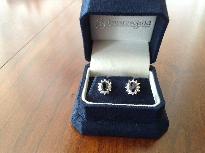 14K white gold diamond and sapphire earrings. 2 oval blue sapphires weighing a total of 1.10 carats. Sapphires surrounded by 24 round diamonds weighing a total of .50 carats. Purchased at Schwartzchild Jewelers. Record of purchase and details available. 