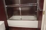 bathtub with sliding glass shower doors
