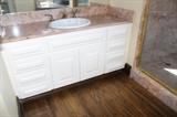 bathroom sink and cabinets with marble counter tops