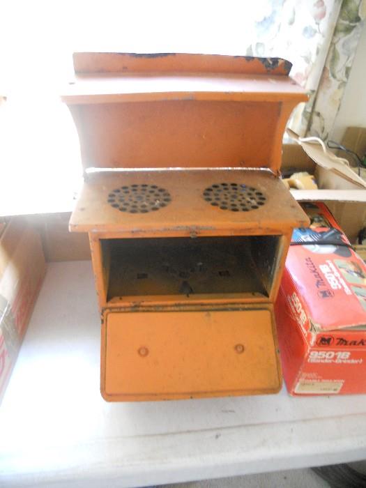 This is a stove from the turn of the century 1900's.  This is the original Easy Bake Oven.  You built a fire in the bottom, and cooked through the burners on top.  A perfect relic for that antique lover.