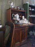 Antique desk and vintage primitive cupboard filled with antique tea cup and saucer sets