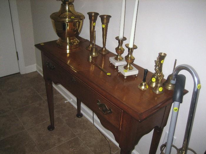 Console table with brass collectibles.