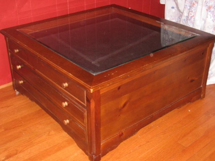 where glass top and wood coffee table with three drawers 38 x 38, 17 tall.
