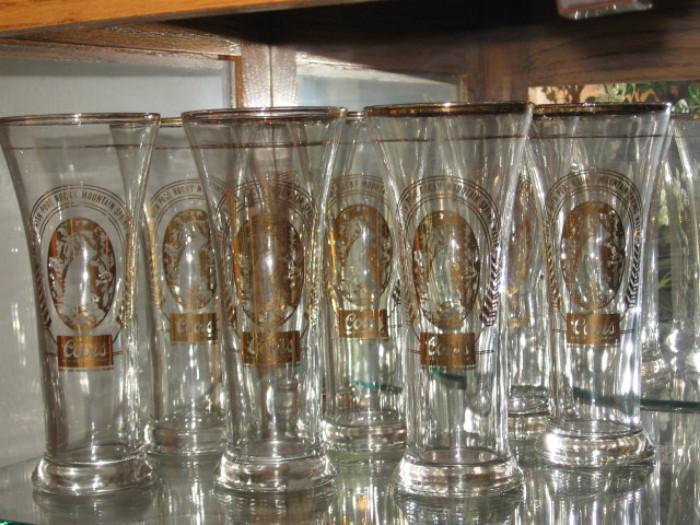 eight tall gold rimmed Coor's glasses