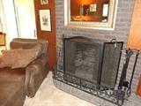 Two sets of fireplace irons, screen and guard; brown leather over-stuffed chair and ottoman