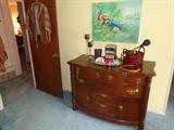Vintage mink stole, curved-front chest with brass pulls.  Decoratives include candles, books, vanity tray
