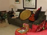 Forest green sofa, large brass, Kate Spade bag, pair table lamps, vintage Taurus guitar made in Barcelona