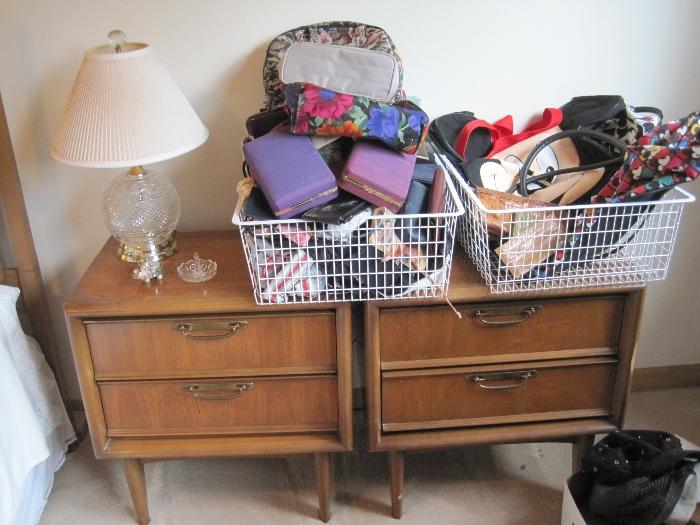 Matched nightstands topped with bargain bins, bags and other goodies. Matched pair of lead crystal dresser lamps.