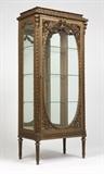 Lot# 1022 A Continental carved gilt wood vitrine cabinet Late 19th / early 20th century, the rectangular top over a laurel and palmette-carved molded frieze above a glazed door with an oval panel crested by a bowknot and floral swags, opening to a mirror-backed interior with three removable glass shelves, with glazed side panels, raised on fluted tapering legs, electrified, with key, 66'' H x 29'' W x 16.5'' D, est: $1500/2000
