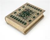 Lot# 1035 A vermeil book-form box Probably late 19th / early 20th century, marked ''HK'' and ''925 Sterling'', rectangular, the hinged lid and ''spine'' decorated with dark green enamel reserves within a design of raised borders, accented with seed pearls and turquoise cabochons, raised on pierced feet, the interior lined with green velvet, 2.75'' H x 7.25'' W x 9'' D, gross weight 81.8 oz troy approximately, est: $4000/6000