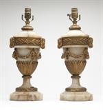 Lot# 1039 A pair of gilt bronze-mounted carved onyx table lamps Early 20th century, each urn-form body decorated with ram's masks, foliage and laurel swags, on an octagonal base, electrified, 2 pcs, each 19'' H x 6.75'' Dia., est: $800/1200