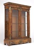 Lot# 1058 An Empire style gilt bronze-mounted bookcase / cabinet Circa 1870, of line-inlaid burr walnut veneer, the rectangular top and molded cornice over a pair of glazed doors flanked by male half figures, the side panels also glazed, enclosing a velvet-lined interior with three glass shelves, on a plinth base with a shaped apron, 55.75'' H x 42.25'' W x 13'' D, est: $1000/2000