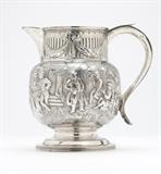 Lot# 1086 A George III silver jug London, 1803, maker's mark ''SA'' (possibly Stephen Adams I), the fluted neck decorated with ribbon-tied laurel swags, the bulbous body in high relief with a continuous scene of figures and a horse in a country village, with engraved inscription to body: ''Regimental Cup / Denbighshire Hussars / Ruthin - 1891 / Won By / Colonel Mesham's / ''Dolphin'' / beating 4 others", 7'' H x 7.25'' W x 5'' D, 20.8 oz troy approximately, est: $900/1200