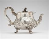 Lot# 1087 A George IV sterling silver teapot
 
1826, London, maker's mark of Paul Storr, the squat bulbous body chased and repousse-decorated with an undulating band of floral sprays, foliage and c-scrolls on a stippled ground and engraved to each side with heraldic crests, issuing a partially fluted floral-decorated spout terminating in a leaf tip, and a scrolling foliate-sheathed handle joined to the upswept foliate scroll rim surrounding the conformingly decorated hinged domed cover surmounted by a rose blossom, the whole on three foliate scrolled feet, 6.75'' H x 10.25'' W x 5.5'' D, gross weight 32.1 oz troy approximately, est: $5000/7000