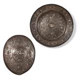 Lot# 1100 A Victorian silver-plated charger & a shield Probably late 19th century, each apparently unmarked, possibly Elkington, each relief-decorated in Renaissance Revival style, the charger: centering a portrait medallion of Francis I, King of France, surrounded by cherubs, satyrs, espagnolettes and military trophies amongst scrolling foliage, the rim with half-figures and palmettes; the shield: centering an oblong panel depicting a scene with knights and mythological beasts, within a wide border of masks, figures, fruit, foliage, musical trophies, and strapwork, mounted to a cloth-covered backing; 2 pcs, the charger 2.75''H x 25'' Dia.; the shield 23.5'' H x 19'' W x 3'' D, est: $2000/3000