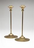 Lot# 1161 A pair of Jessie M. Preston brass candlesticks Circa 1905, with Anderson foundry mark, each with a detachable floriform socket over a slender stem on a stepped circular base, 2 pcs, each 12'' H x 5.375'' W, est: $2000/3000