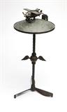 Lot# 1171 A cast metal aeronautical smoking stand Mid 20th century, marked ''Patented 74807'', the domed top relief-cast with a map of the world, topped with a model of a plane with spinning propeller and fitted with holders for accessories, over a winged standard on a propeller blade-form base, 30.5'' H x 15'' Dia., est: $500/700