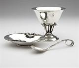 Lot# 1174 Three sterling silver articles by Georg Jensen After 1945, each with maker's mark, further marked ''Sterling / Denmark'', comprising: a ''Blossom'' pattern dish, further marked ''2'', of shallow oval form (1''H x 5.25''W x 3.75''D) (3.51 oz troy); a bowl, further marked ''17 / A'' and with designer's mark of Johan Rohde (1856 - 1935), of tapering circular form on an openwork foliate stem over a stepped circular foot (4.25''H x 4.5''Dia.) (6.19 oz troy); and a sugar spoon, further marked ''41'', the leaf-shaped bowl extending to a scrolled handle with a berried terminal, (5.5'') (1.05 oz troy); 3 pcs, 10.7 oz troy tw approximately, est: $1200/1800