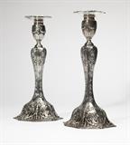 Lot# 1194 A pair of American sterling silver candlesticks Designed 1909, maker's mark of Graff, Washbourne and Dunn, New York, NY, retailer's mark of C.D. Peacock, further marked ''10 1/4 oz / Sterling / Weighted with pitch'', ''3486 / 47 / 11 in'', and ''Patented / 5/18-25-1909'', each with a foliate-rimmed removable nozzle over an urn-form socket decorated with bowknots and laurel swags, on a baluster-form standard decorated with cartouches, flowers and foliage within scrolled borders, on a conformingly decorated pierced domed foot, each 11.25'' H x 5.5'' Dia., gross weight 37.5 oz troy tw approximately, est: $300/500