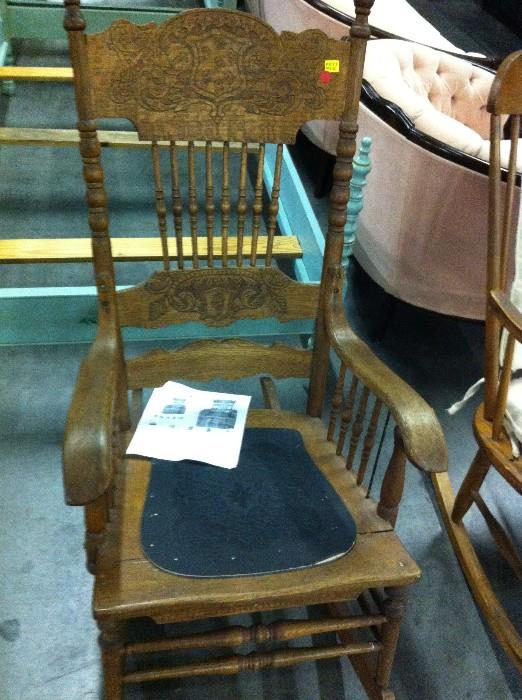 Decorative Rocking Chair with carved wooden and black bottom cushion.
