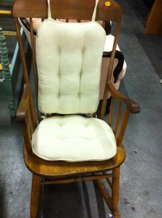 Wooden Rocker with arms and beige cushion
