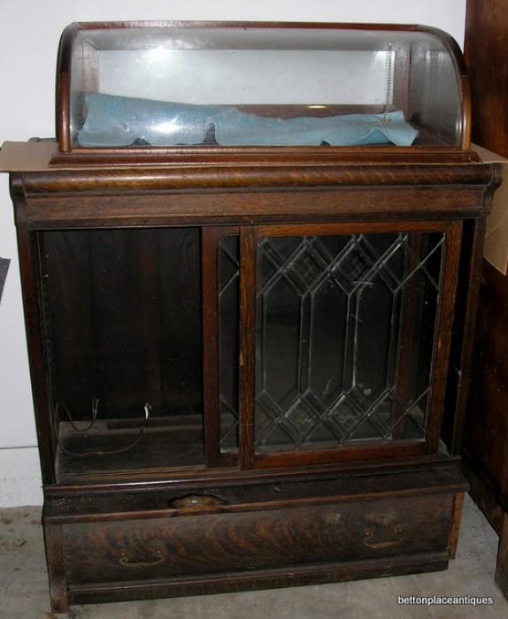 two pieces, display on top, the base is a neat antique piece that could be repurposed, sliding leadlight doors, all oak