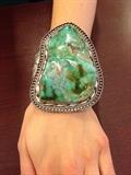 Lot#:	5
Description:	Jewelry HUGE Sterling Silver Turquoise Bracelet
Stunning huge sterling silver cuff bracelet with Southwestern / Native American Indian style design. Featuring a large vibrant turquoise stone slab with wavy surface. Stone is accented with twisted rope designs, cuff has cut out and pressed designs. Unmarked, consignor states this piece is sterling. Measures: 6.25" around with 1.5" opening x 3.75" wide. Total weight: 6.96 ozt. 