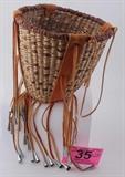 Lot#:	35
Description:	Vintage Hand Woven Apache Burden Basket
Wonderfully hand woven American Apache Indian Burden Basket. This cone shaped basket is made of beautiful sun bleached split yucca and devil’s claw fiber over a mulberry rod core; these baskets are skillfully hand woven by tribe’s women with lengths of different grasses that are spliced in to create an intricate, colorful pattern. It features a rounded bottom with soft buckskin carrying strap and decorated with buckskin tassels with tin cone jingles. Appears to be In excellent condition. Measures 8" tall not including the tassels x 8.25" diameter at the top.
From the internet: "The burden basket is the most traditional of all forms in that it was the last form to be made more for tourists than for self use. Burden baskets were made as utilitarian baskets. Those with original raw hide, cones, and original straps are most valuable."