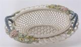 Lot#:	212
Description:	Belleek Ireland Porcelain Woven Oval Basket & Box
Beautiful large Belleek, Ireland translucent eggshell porcelain woven 3 strand oval basket. This basket was manufactured in Ireland in 1999 for the “Belleek Annual Basket” collection. This limited edition Henshall Oval Basket features a delicate open lattice work in lovely ivory colored porcelain with a soft iridescent or pearl luster finish. It has braided rope – like trim with applied blue handles and accented with sprigs of yellow and pink flowers. The edging is an attractive dainty scalloped openwork. Marked on the bottom with the brown stamp and maker’s label; Wolfhound with head turned to face the Round Tower believed to be modeled on Fermanagh's own Denenish Round Tower, the Irish Harp and sprigs of shamrock. In excellent condition, with no chips, cracks, or visible signs of wear with original green box! Measures 2.75” tall x 8” across. 
Look throughout the auction for other Irish Belleek Parian China piece