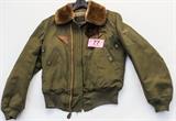 Lot#:	77
Description:	WWII Era Army Air Force Flight Bomber Jacket
A fantastic vintage Army / Air Force flight / bomber jacket manufactured by Metro Sportswear, Inc. The olive green jacket features a cotton exterior, faux fur collar, wool lining, zippered front, two snap close front pockets, two leather accent pieces just below each side of the collar, and ribbed sleeve cuffs and bottom. The jacket has normal wear with several stains, some fraying in the material at the bottom front, and holes in the ribbing and where the sleeves join the ribbing. Label of jacket reads, "Jacket - Intermediate - Flying; Type B-5A; Spec No. 3220-A; Size 38; Stock No. 8300-470732; Property, U.S.Army, Air Forces".
Tag Words: Military; militaria, WWII, World War II