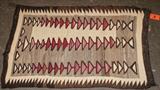 Lot#:	4
Description:	Early Southwestern Navajo Crystal Woven Rug
Wonderful vintage Southwestern style Native American Navajo woven area rug circa 1915. From the Crystal Region it features rows of interconnecting triangles with a serrated geometric border. Created in natural colors of brown, cream, and tan and accented with red. Very finely woven with hand spun wools, this rug is in excellent pre-owned condition; tightly woven with some areas of light wear, and fading and is from a non-smoking home. some fraying at a couple corners. A gorgeous piece to add Southwest flare to any room! Measures approx 31.5" wide x 50" long. 
Tag words: Textile, saddle blanket, carpet, wearing, Chinle, Two Gray Hills, Intdes