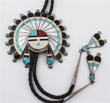 Lot#:	175
Description:	Jewelry Sterling Silver Zuni Sunface Bolo Tie
Gorgeous huge sterling silver bolo tie with Southwestern / Native American Indian style design. Bolo is shaped like a Zuni sunface with headdress made up of inlaid tortoise shell, turquoise, mother of pearl, and polished red coral. Hangs on braided leather ties and is completed by matching tips. Bolo measures: 4" in diameter, total weight: 2.99 ozt.