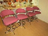 Four Bar Stools that swivel. Cloth covered with metal base.