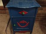 blue and red small cabinet with green handles
