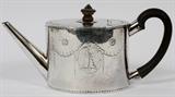 Lot#1018, GEORGE III STERLING TEAPOT BY ROBERT MAKEPEACE & RICHARD CARTER, LONDON, 1777-78, H 4 3/4", L 9 1/2"An oval sterling silver teapot with hinged lid and wood scroll handle, chased swags and oval medallions in the Adams style.  Hallmarks include a lion passant, crowned leopard, and date letter b, as well as the maker's mark for Robert Makepeace and Richard Carter (see additional photo).  Weighs approximately 14.3 troy oz.