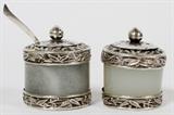 Lot#1038, SILVER-MOUNTED JADE CONDIMENT SET, TWO PIECES, H 1 1/4"/Matched set includes 1 jar with removable cover and spoon, and 1 shaker with pierced cover; jade is pale green to white in color, the silver mountings are not marked.  Diameter 1 1/8".  Circa 1900.