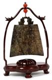 Lot#1125, CHINESE ARCHAIC CARVED JADE BELL, H 4", W 4"Teak frame, H 8 1/2". Coral beads at top of frame. In yellow silk box.