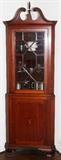 Lot#1161, MAHOGANY CORNER CABINET, C. 1930, H 79", W 29", D 16"Satinwood inlays. Circa 1920 - 30. On ogee feet, fenestrated door with 13 sections. Canted corners. Arched pediment with central flame finial.  Probably by Baker Furniture Co.