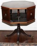 Lot#1182, MAHOGANY OCTAGONAL REVOLVING TABLE, H 38", W 24", D 24"Revolving octagonal book table circa 1940, tooled leather top. Pedestal base with brass cap feet on casters.