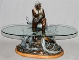 Lot#2070, BURL JONES (USA), BRONZE SCULPTURE TABLE, 1999, H 34", L 36", D 26", "MATCHING THE HATCH", #17/30///Polychrome bronze figural glass top table, in the form of a fly fisherman at waters edge (glass top). Artist mark, numbered, dated, and titled on side. Mounted on wooden base.