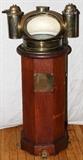 Lot#2230, HENRY HUGHES & SONS BRASS AND WOOD BINNACLE AND COMPASS C. 1900 H 43"Husun compass binnacle by Henry Hughes & Sons, having an octagonal shape, brass compass housing with functional floating compass card and oil illuminating lamps on each side in cylindrical brass cases, Henry Hughes mfg. plate on front of binnacle.
