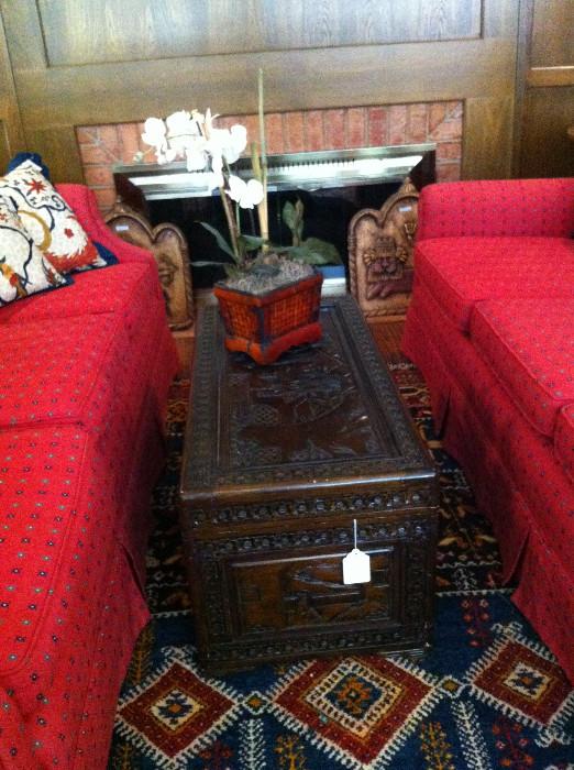    matching red sofas; carved Asian chest; one of many rugs