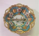 Large and showy reticulated porcelain bowl with raised gold work, a souvenir piece from the 1904 World's Fair, in St. Louis, Missouri. The turquoise ground is embellished with gold medallions and hand-painted floral reserves. The center of the bowl depicts the grand Hall of Machinery at the fair. 