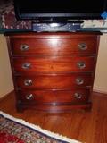 A four drawer dresser with a cherry stain