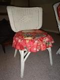 Photo 3 of 3: A white wicker chair with a red floral cushion.