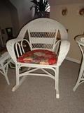 Photo 2 of 3: A rocking chair of white wicker with a red floral pillow