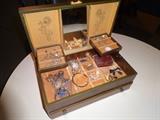 A jewelry box with some unique jewelry pieces.