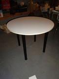 A white table with black legs.