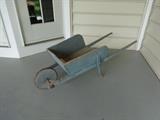An antique blue wooden wheelbarrow